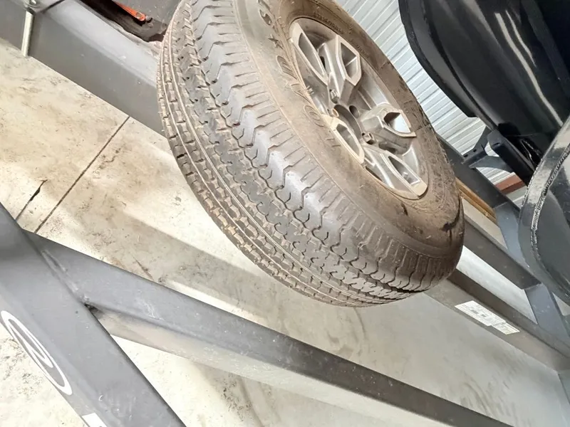 Slide: The Image of A spare tire is mounted underneath a vehicle on a lift. - 34