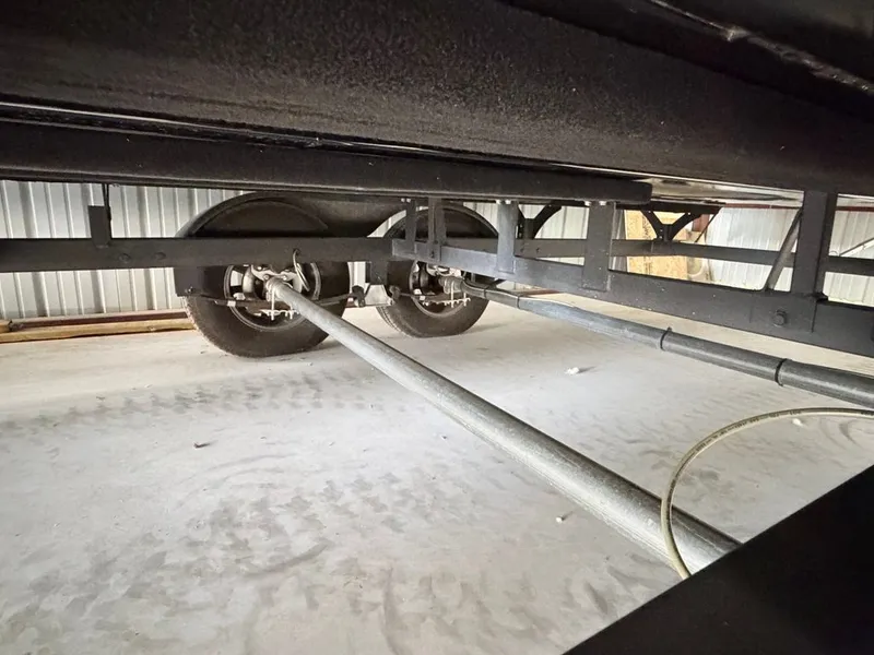 Slide: The Image of Underside view of a boat trailer with two wheels and metal frame in a storage facility. - 30