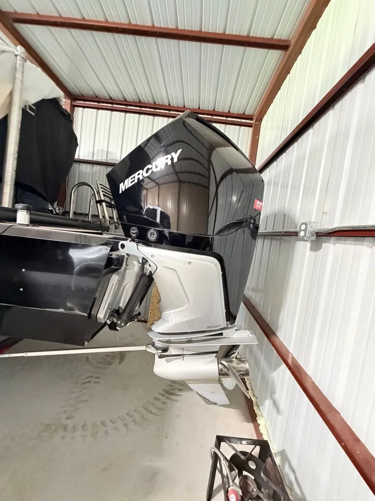 Slide: The Image of A Mercury outboard motor is mounted on a boat stored in a covered area. - 20