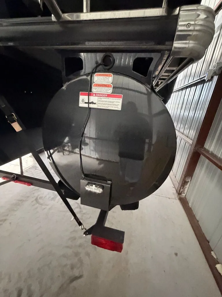 Slide: The Image of Rear view of a boat trailer with a round cover and warning labels. - 23