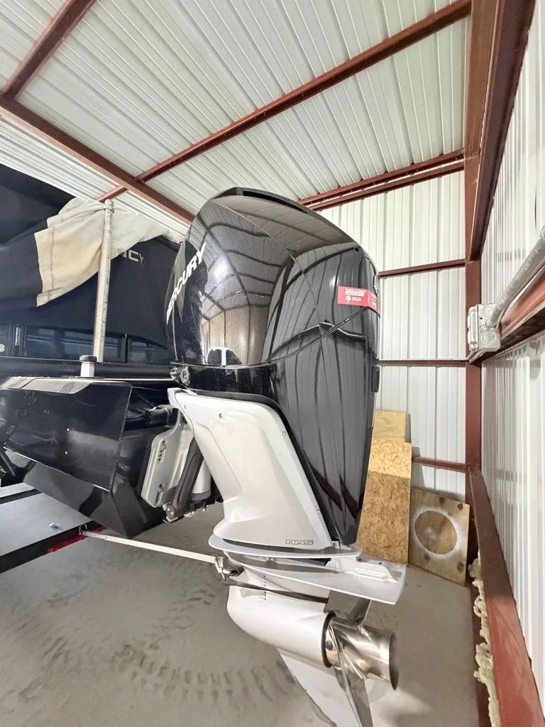Slide: The Image of Outboard motor of a 2025 Regency 230 LE3 in a storage facility. - 21