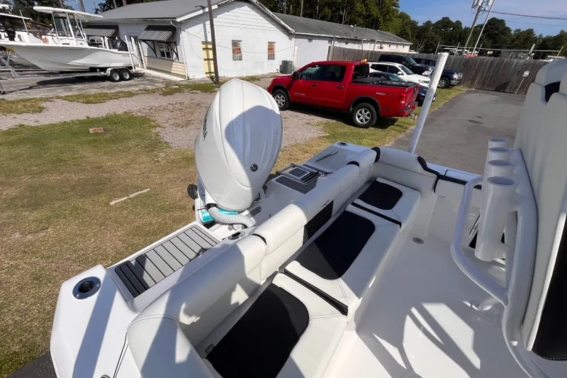 Slide: The Image of 2027 Tidewater 210 LXF boat interior with motor, parked near vehicles and buildings. - 14