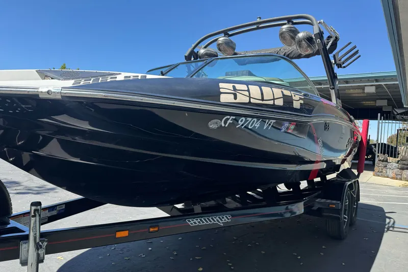 Slide: The Image of 2019 Sanger 212 SL boat on trailer, black exterior, parked outdoors. - 6