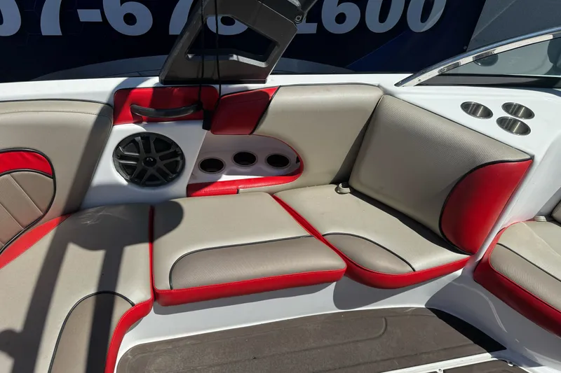 Slide: The Image of 2019 Sanger 212 SL boat interior with red and beige seating, speaker, and cup holders. - 16