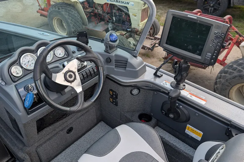 Slide: The Image of 2012 Lund 1875 Pro-V IFS boat dashboard with steering wheel and electronic display. - 11