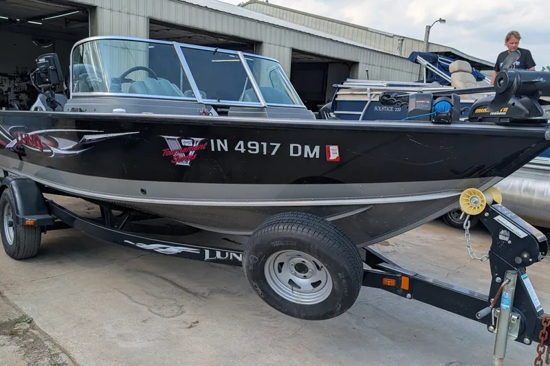 Slide: The Image of 2012 Lund 1875 Pro-V IFS boat on trailer, parked outside a garage. - 4