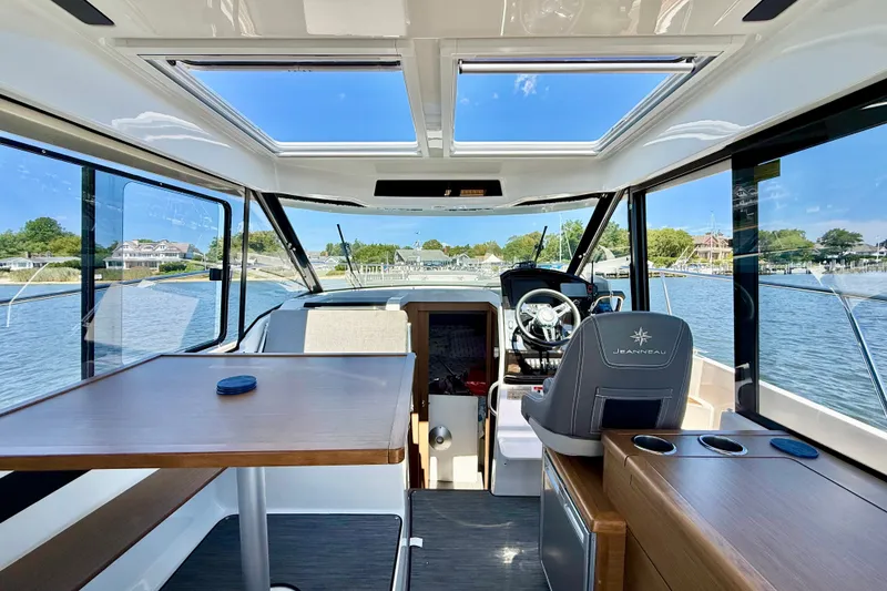 Slide: The Image of Interior of 2019 Jeanneau NC 895 boat with helm, table, and panoramic windows. - 13