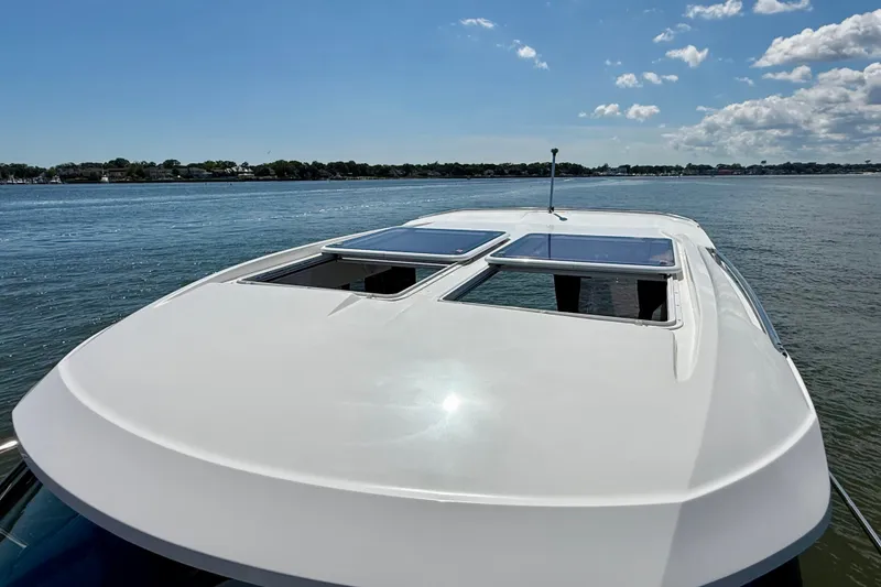 Slide: The Image of 2019 Jeanneau NC 895 boat with sunroof panels on calm water under blue sky. - 26
