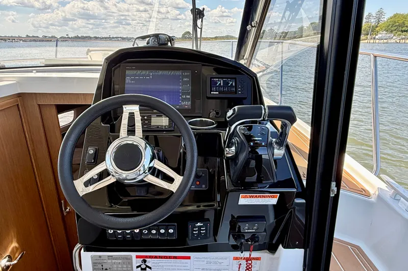 Slide: The Image of Cockpit of 2019 Jeanneau NC 895 boat with steering wheel and navigation controls. - 18