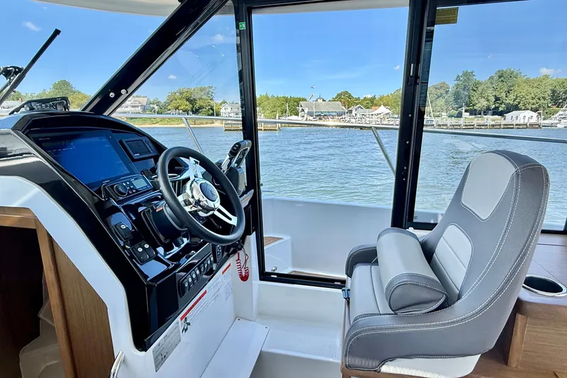 Slide: The Image of Interior view of 2019 Jeanneau NC 895 boat cockpit with steering wheel and comfortable seating. - 17