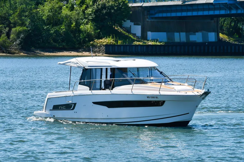 Slide: The Image of 2019 Jeanneau NC 895 boat cruising on a sunny day near a bridge. - 3
