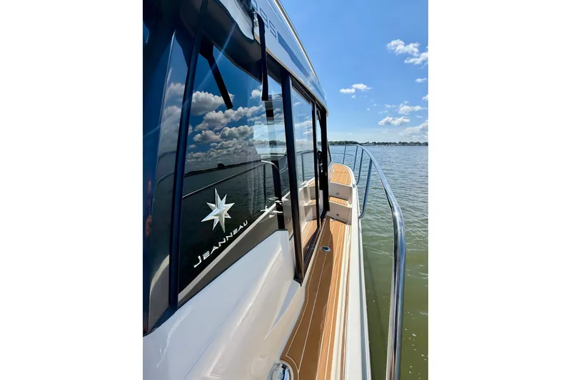 Slide: The Image of 2019 Jeanneau NC 895 boat on water, reflecting blue sky and clouds. - 22