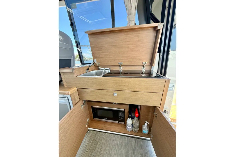 Slide: The Image of Compact kitchen area in a 2019 Jeanneau NC 895 boat with sink and microwave. - 16