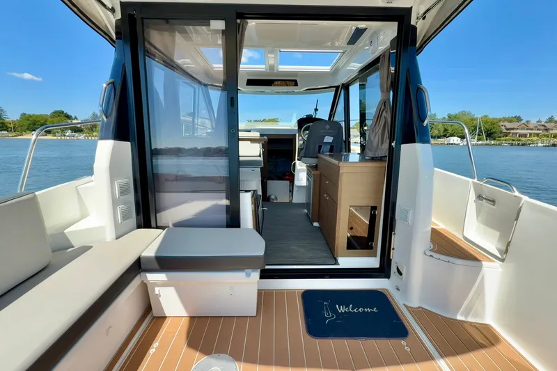 Slide: The Image of 2019 Jeanneau NC 895 boat interior with seating, helm, and scenic water view. - 7