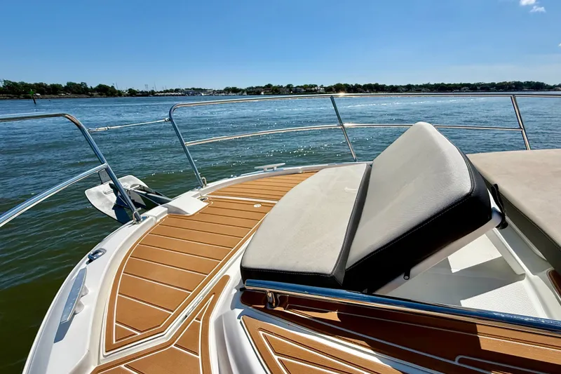 Slide: The Image of 2019 Jeanneau NC 895 boat deck with cushioned seating, overlooking calm waters. - 25