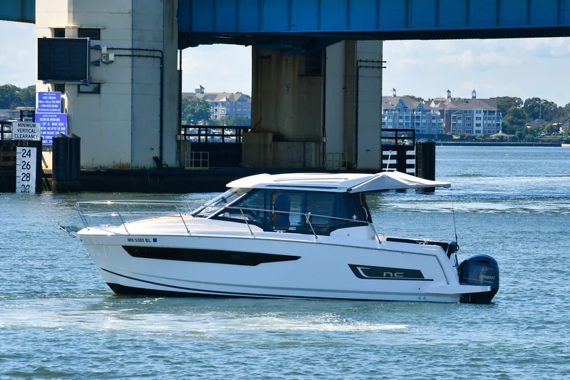 Slide: The Image of 2019 Jeanneau NC 895 boat cruising under a bridge on a sunny day. - 5