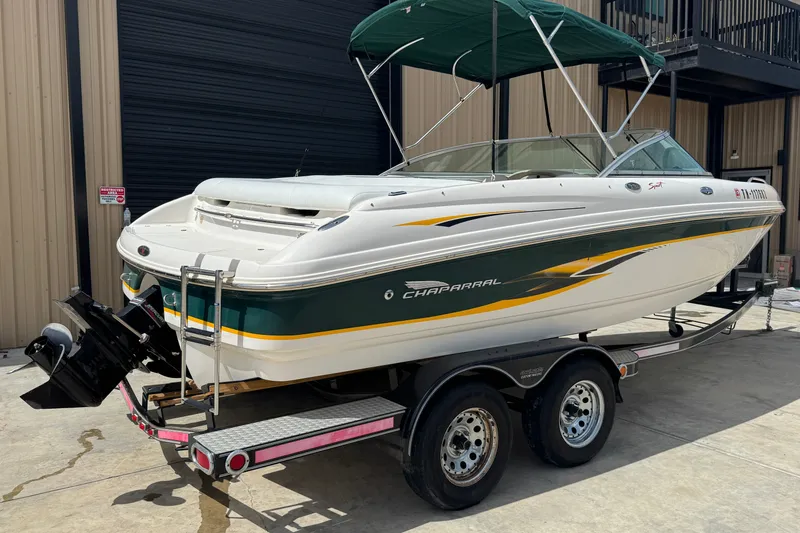Slide: The Image of Chaparral 216 SSi 2000 boat on trailer, green and white design, parked outdoors. - 3