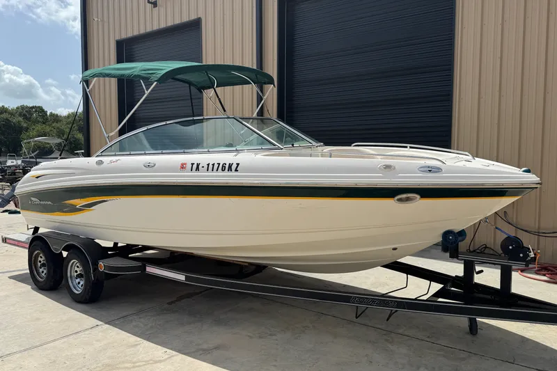 Slide: The Image of 2000 Chaparral 216 SSi boat on trailer, green canopy, parked outside a building. - 2