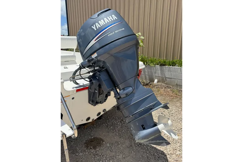 Slide: The Image of Een Yamaha buitenboordmotor is bevestigd aan een boot, rustend op een grindoppervlak. - 15