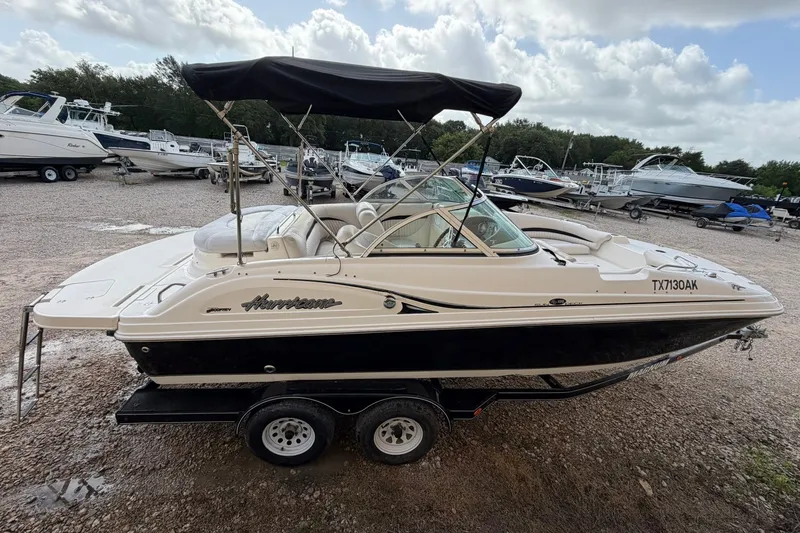 Slide: The Image of 2009 MasterCraft X-45 mit schwarzem Bimini-Top, auf einem Anhänger, umgeben von anderen Booten. - 2