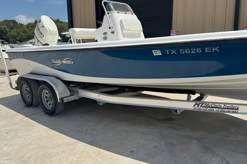 Slide: The Image of 2018 Blue Wave 2200 PureBay boat on trailer, parked outdoors. - 2