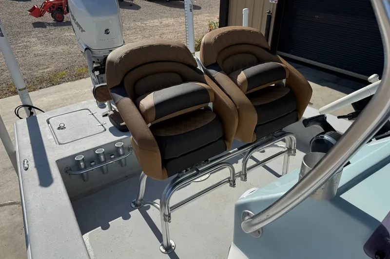 Slide: The Image of 2021 Haynie 25 Magnum boat with dual cushioned seats and Mercury outboard motor. - 13