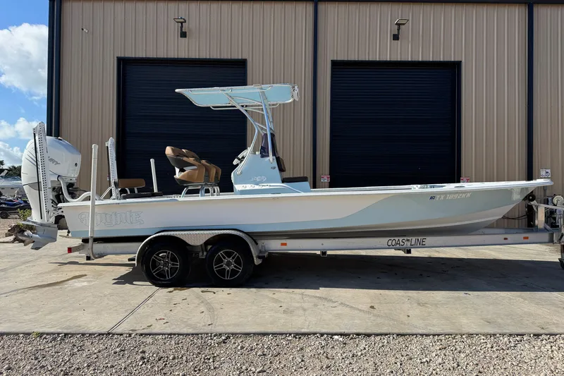 Slide: The Image of 2021 Haynie 25 Magnum boat on trailer, parked outside a building. - 2