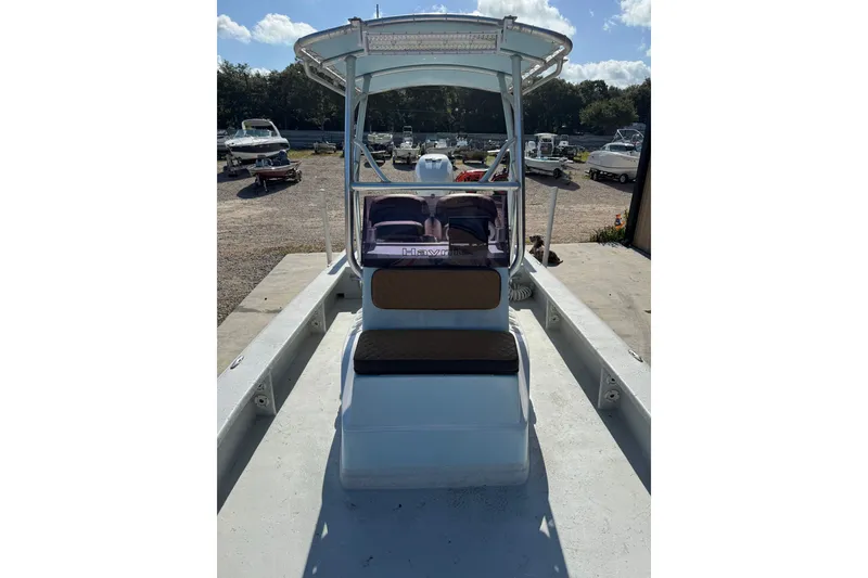 Slide: The Image of 2021 Haynie 25 Magnum boat with center console and seating, parked outdoors. - 7