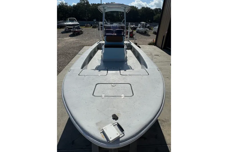 Slide: The Image of 2021 Haynie 25 Magnum boat, docked outdoors, showcasing spacious deck and sleek design. - 4
