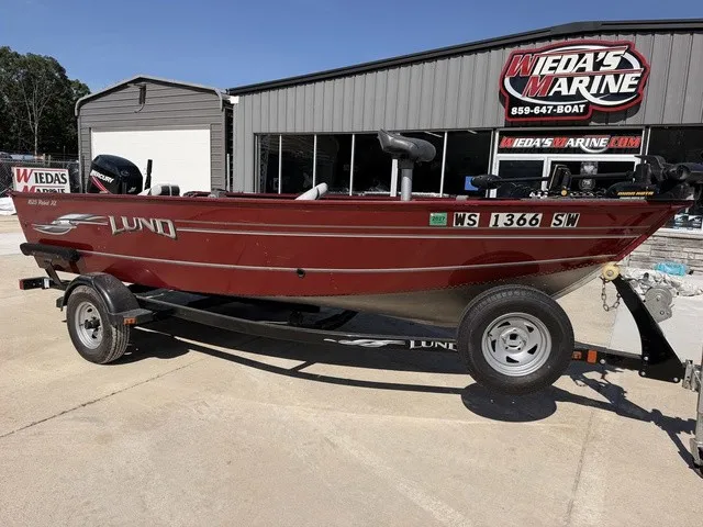 Slide: The Image of A red 2009 Lund 1625 Rebel XL boat on a trailer in front of a building. - 8