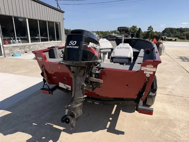 Slide: The Image of A red boat with a Mercury 50 outboard motor is on a trailer in front of a building. - 2
