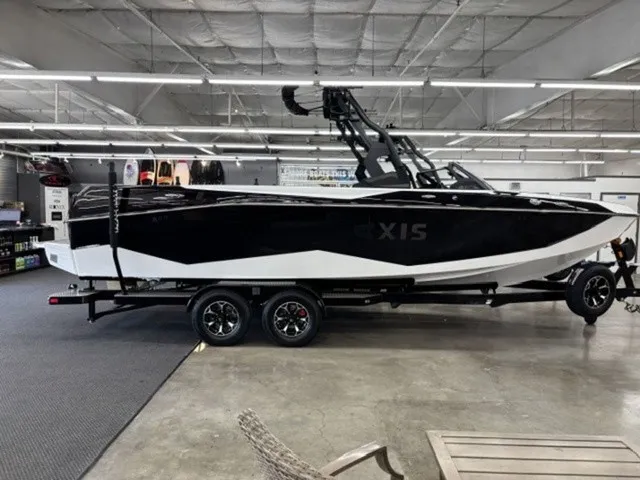 The Image of A 2027 Axis Wake Research T250 is on a trailer in a showroom. - 1