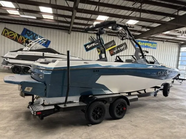 Slide: The Image of A 2027 Axis Wake Research A225 boat on a trailer in a warehouse setting. - 4