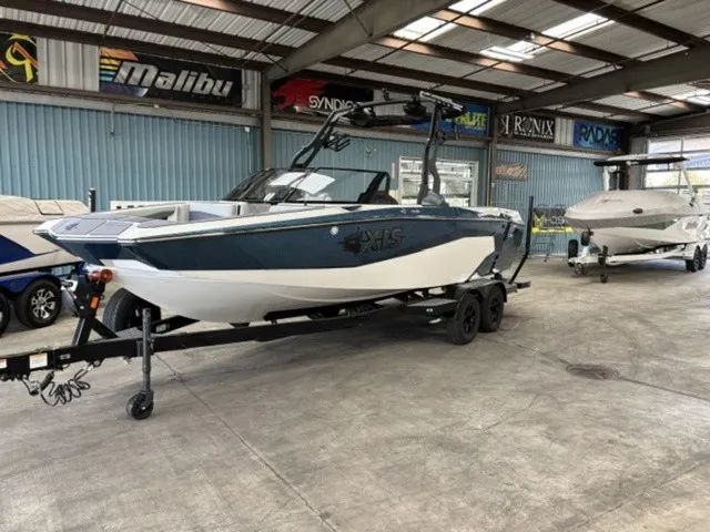 Slide: The Image of A 2027 Axis Wake Research A225 boat on a trailer in a warehouse setting. - 2