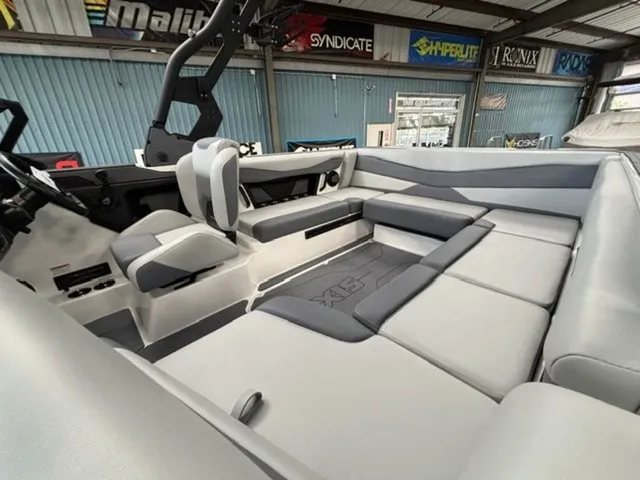 Slide: The Image of The image shows the interior of a 2027 Axis Wake Research A225 boat with gray upholstery. - 9