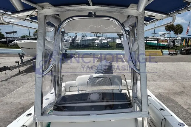 Slide: The Image of A 2013 Sportsman Heritage 211 Center Console boat with blue canopy and clear side panels. - 3