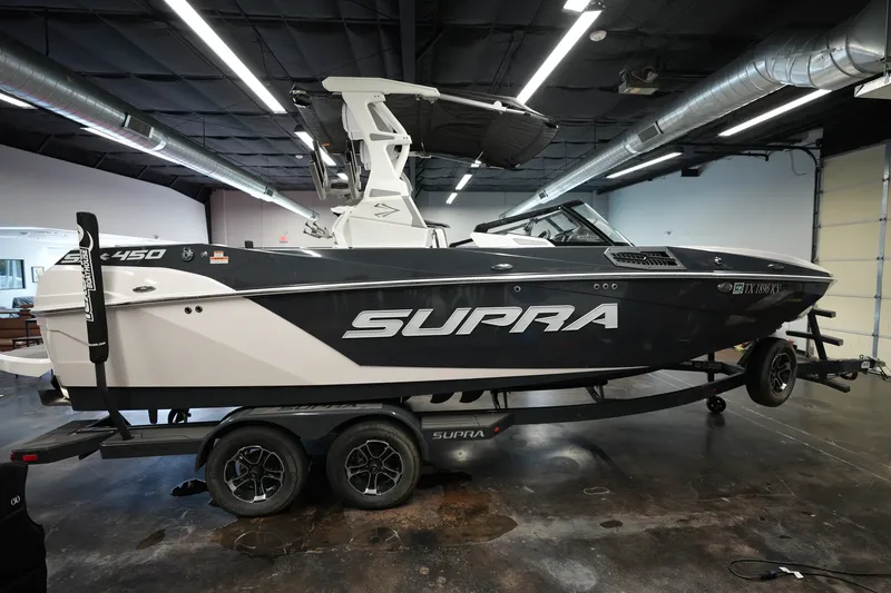 Slide: The Image of 2023 Supra SA 450 boat on trailer in indoor showroom setting. - 7