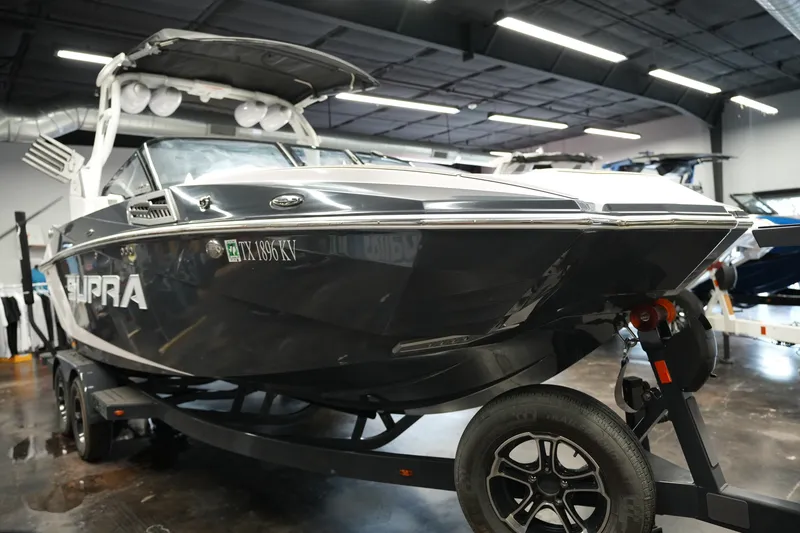 Slide: The Image of 2023 Supra SA 450 boat on trailer in showroom, showcasing sleek design and modern features. - 8