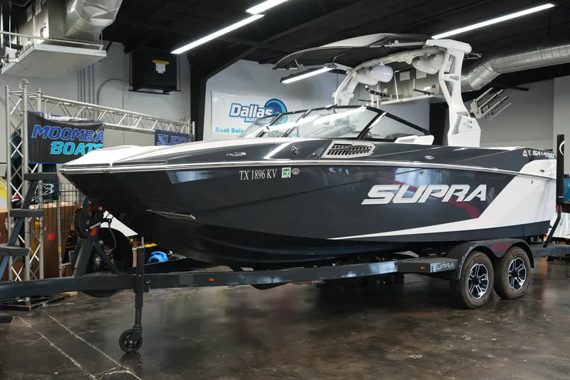 Slide: The Image of 2023 Supra SA 450 boat displayed indoors on a trailer. - 10