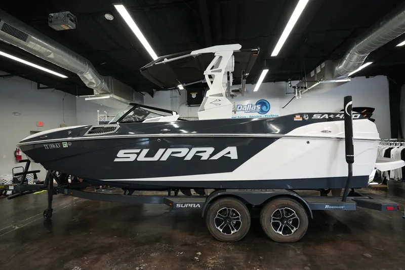 The Image of 2023 Supra SA 450 boat displayed indoors on a trailer. - 1