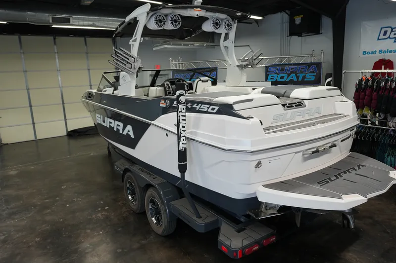 Slide: The Image of 2023 Supra SA 450 boat in showroom, featuring sleek design and advanced audio system. - 3