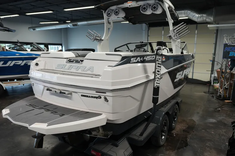 Slide: The Image of 2023 Supra SA 450 boat in showroom, featuring sleek design and advanced wakeboarding features. - 6