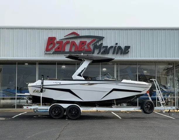 The Image of A 2027 Tigé Z1 boat on a trailer in front of a building labeled "Barnes Marine." - 1