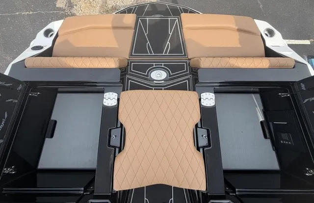 Slide: The Image of The image shows the rear of a 2027 Tigé Z1 boat with cushioned seats and storage compartments. - 22