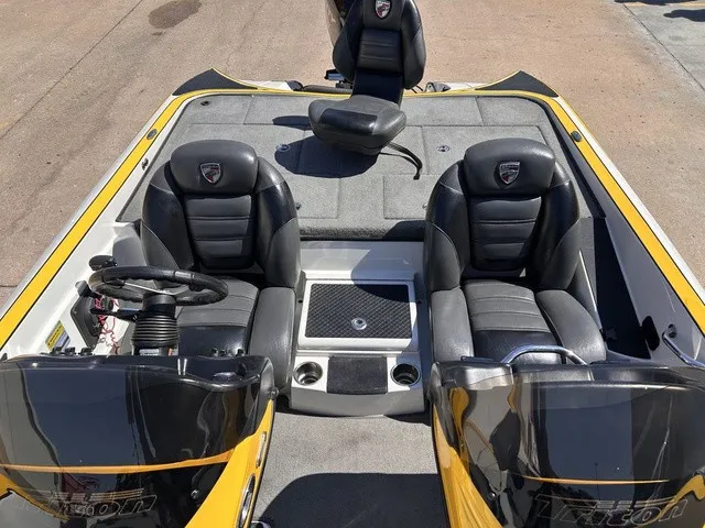 Slide: The Image of The image shows the cockpit of a 2015 Triton 20 TrX boat with two black seats and a steering wheel. - 20