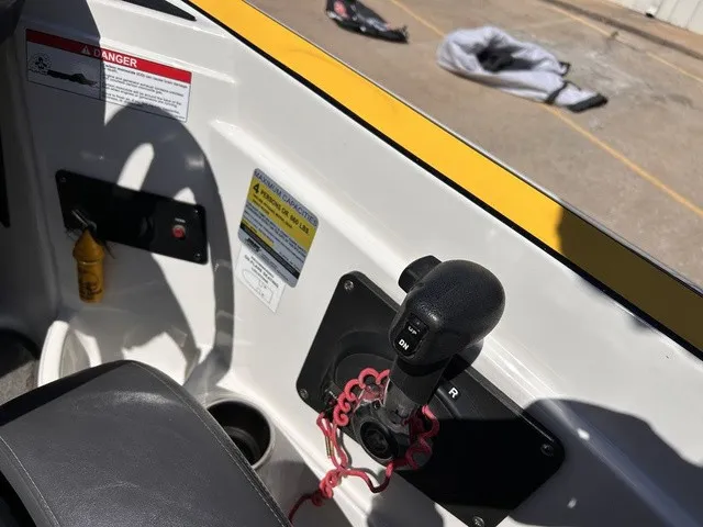 Slide: The Image of Close-up of a 2015 Triton 20 TrX control area with gear lever and safety warnings. - 14