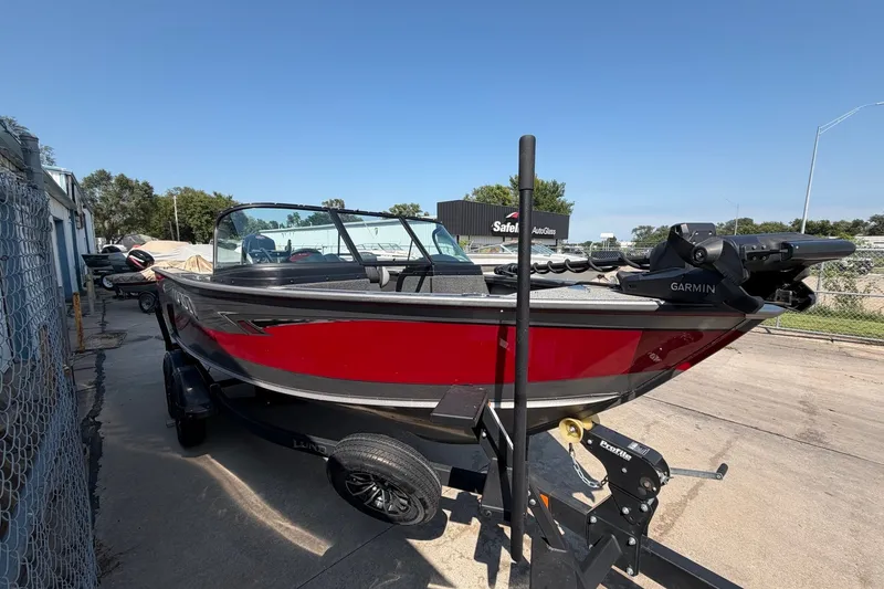 Slide: The Image of 2024 Lund 1875 Fisherman boat with Garmin equipment on a trailer, parked outdoors. - 4
