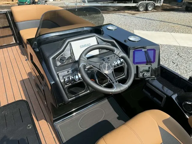 Slide: The Image of The image shows the cockpit of a 2027 Bentley Pontoons Elite 223 Admiral. It features a modern steering wheel, a Simrad display, and another digital display. The seats are elegantly brown. - 6