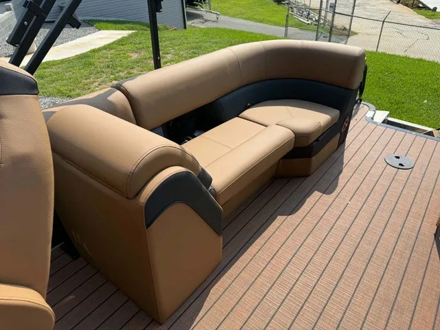 Slide: The Image of The image shows a luxurious seating area on a 2027 Bentley Pontoons Elite 223 Admiral. The upholstery is brown and black, set on a wooden deck. - 3