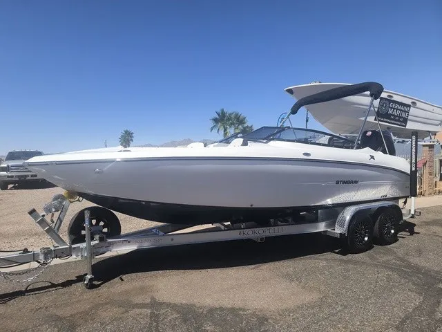 Slide: The Image of A white Stingray 23 OSX boat from 2027 is on a trailer in a sunny setting. - 26